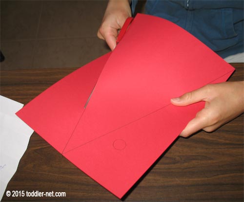 Cut out red triangle for paper plate Santa's hat and shoulders
