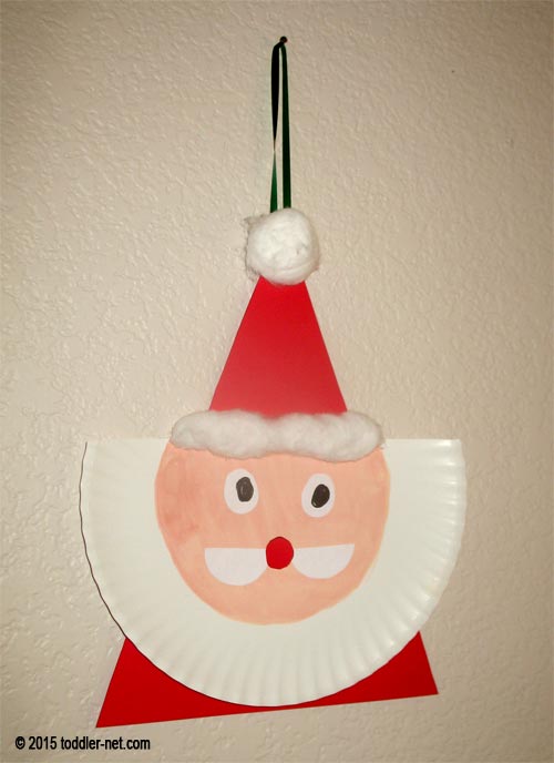 Paper plate Santa is hanging on the wall